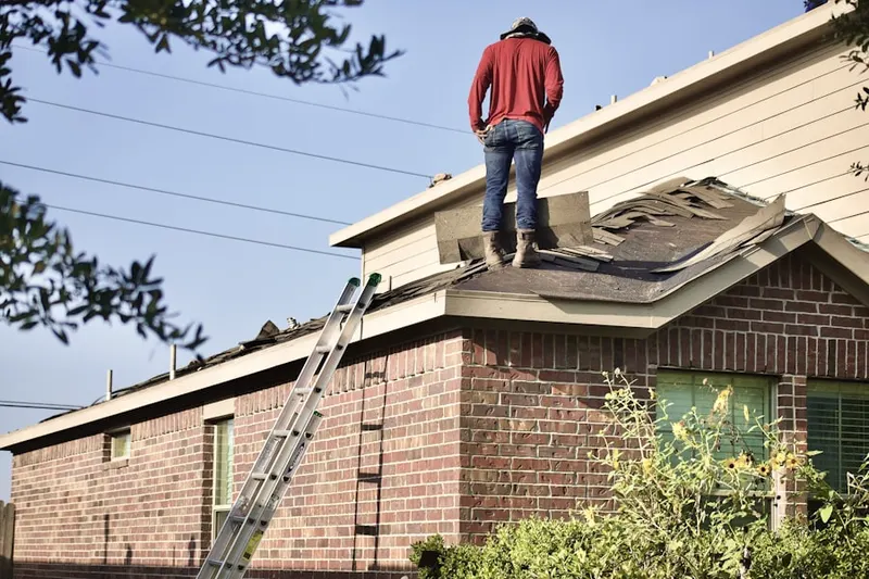 Professional roofer working on a residential roof in West Farm
